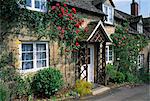 Stone cottages with roses on the walls in the Cotswolds village of Winchcombe, Gloucestershire, England, United Kingdom, Europe