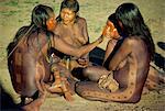 A group of Xingu women applying body paint in Brazil, South America