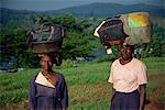 Heavy loads of washing carried on head to be washed in river, Uganda, East Africa, Africa