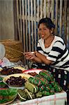 Porträt einer jungen laotische Frau lächelnd und Blick in die Kamera, Verkauf von Essen in einem Straßenmarkt in Luang Prabang in Laos, Indochina, Südostasien, Asien