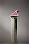 pink high heel shoe on a pedestal