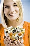 woman eating a salad made of money