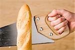 hand sawing a loaf of french bread