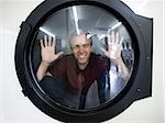 man inside a commercial clothes dryer at a laundromat