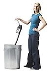 woman throwing a gas pump nozzle in the trash