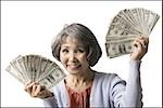 senior woman with hands full of dollars