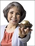 senior woman holding a golden egg