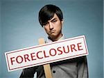 man holding a foreclosure sign