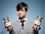 man holding two jars of coins