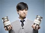 man holding two jars of coins