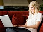 woman using a laptop on a sofa