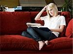 woman studying on a red sofa