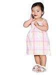 baby girl in a pink dress holding a cell phone