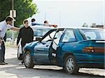 people looking at a car after an accident