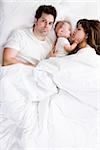 couple and baby in bed