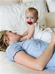 woman lying on a bed with her baby girl