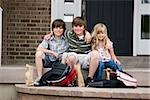 children sitting on the front step of their house