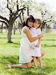 two girls in a blossoming orchard