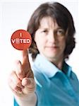 woman holding a "I voted" sticker