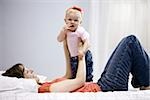 mother and baby girl lying on a bed