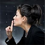 businesswoman putting finger to lips