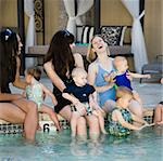 women by the pool with their babies