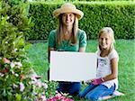 mother and daughter holding a blank sign