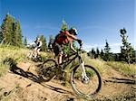 mountain bikers riding down a trail