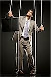 Puppeteer Holds The Puppet Business Man On The Ropes Stock Photo, Picture  and Royalty Free Image. Image 28107184.