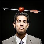 businessman with an apple on his head that has been shot with an arrow