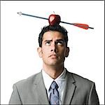 businessman with an apple on his head that has been shot with an arrow