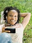 woman in the backyard listening to a digital music player