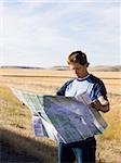 man looking at a map on the side of the road