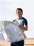 man looking at a map on the side of the road