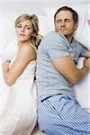 couple with marriage problems lying in bed