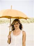 femme tenant un parasol à la plage