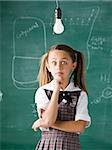 girl in a classroom with a light bulb above her head