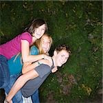 three teenagers climbing on each other