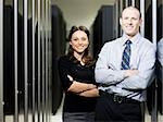 businesspeople standing in a server room with their arms folded