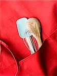 tablier rouge avec une spatule, un fouet et une cuillère à mélange en bois