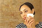 Pensive young woman holding plastic cup