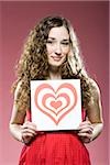 woman holding a red heart over her chest