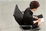 Businesswoman writing in personal organizer, Munich, Bavaria, Germany