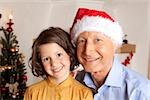 Girl and grandfather with Santa hat