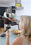 Couple senior en cuisine avec le vin rouge