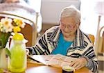 Senior woman reading magazine in retirement home