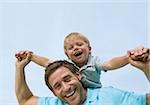 Father carrying son piggyback in autumnal park