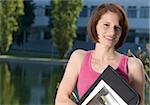 Student holding folder in front of university