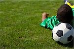 Joueur de football brésilien, couché sur l'herbe