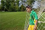 Brazilian soccer player standing in goal net